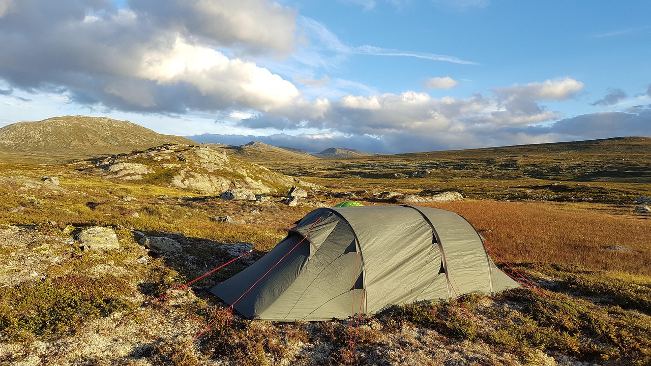 Hiker packing backpack at campsite